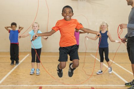 Diverse group of elementary children jumping rope
